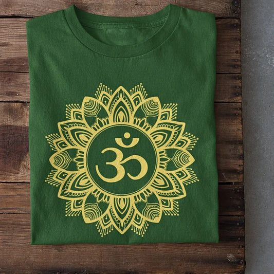 Green t-shirt with yellow Om mandala print, folded on wooden surface, unisex design.