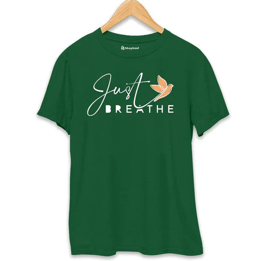 Green printed t-shirt with 'Just Breathe' text and orange bird graphic, hanging on hanger