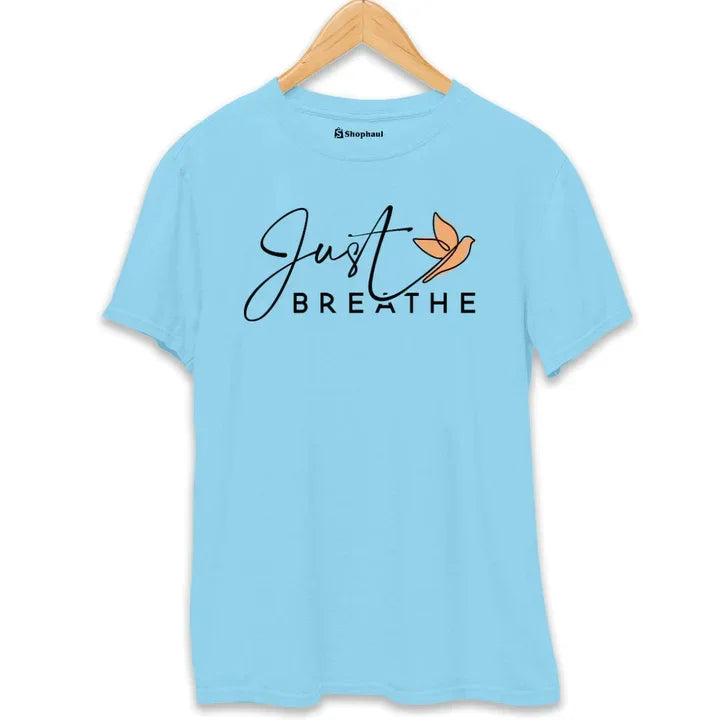 Sky blue printed t-shirt with 'Just Breathe' text and orange bird graphic, hung on hanger